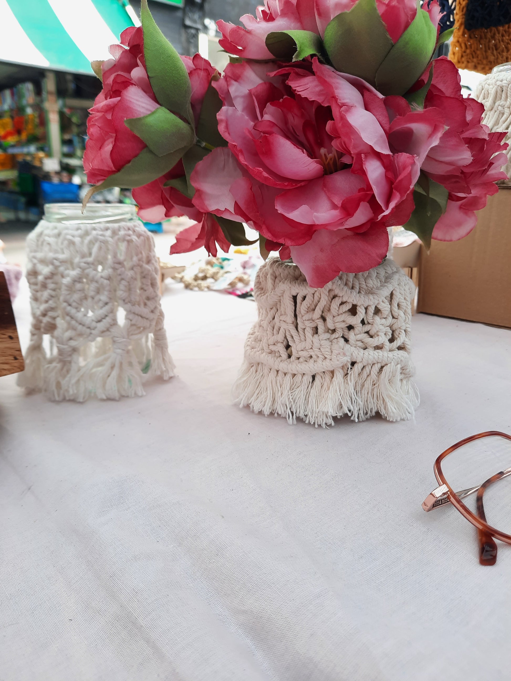 Floral arrangement in a macrame holder on a table with a blurred background