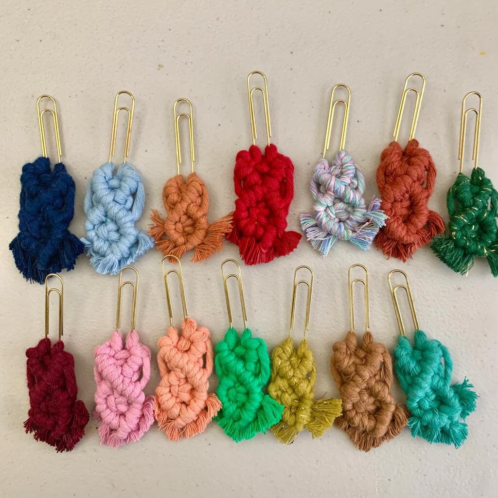 Colorful yarn-wrapped paper clips bookmarks on a beige background