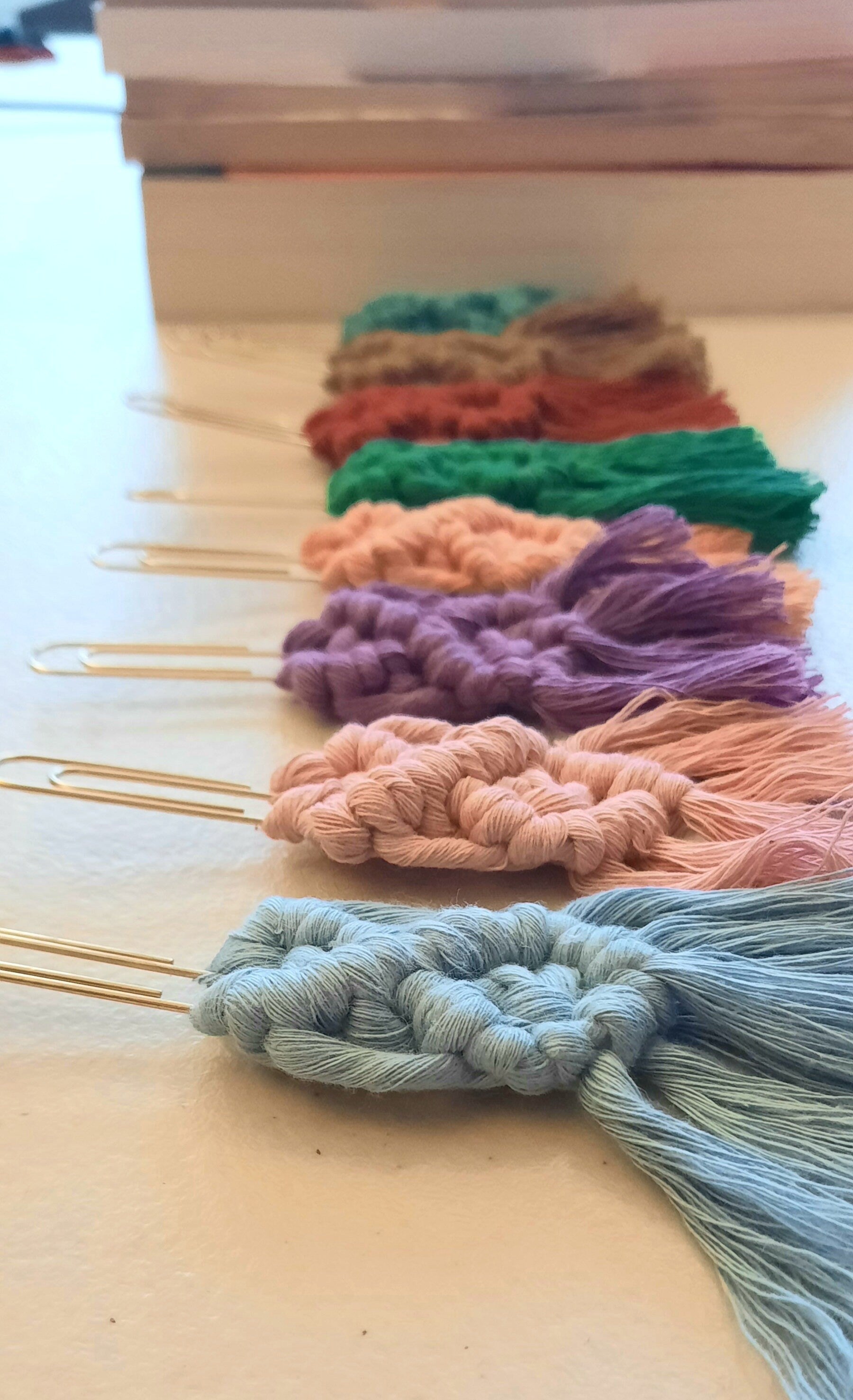 Colorful yarn paper lip bookmark samples on a wooden board