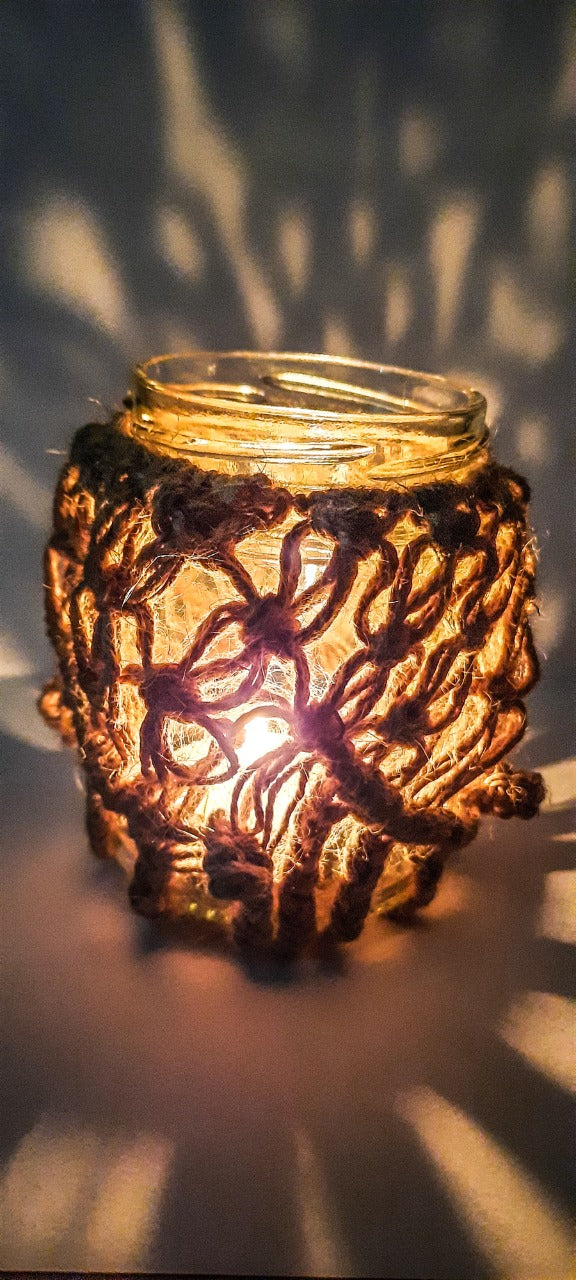 Decorative glass lantern with intricate designs, emitting a warm glow.